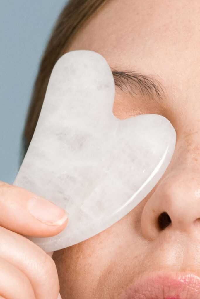 Utilisation d'un Gua Sha en quartz rose pour le drainage lymphatique du visage.